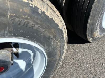 Trailer wheel and tire with visible marking 'THR22.5' and alloy rim; dirt on tire surface.