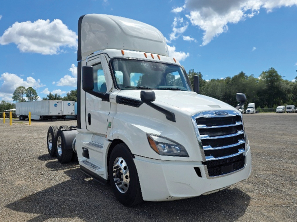 Freightliner Cascadia daytime cab tractor showing front grille with chrome bars and headlamps; white exterior, side mirrors, and dual rear wheels.