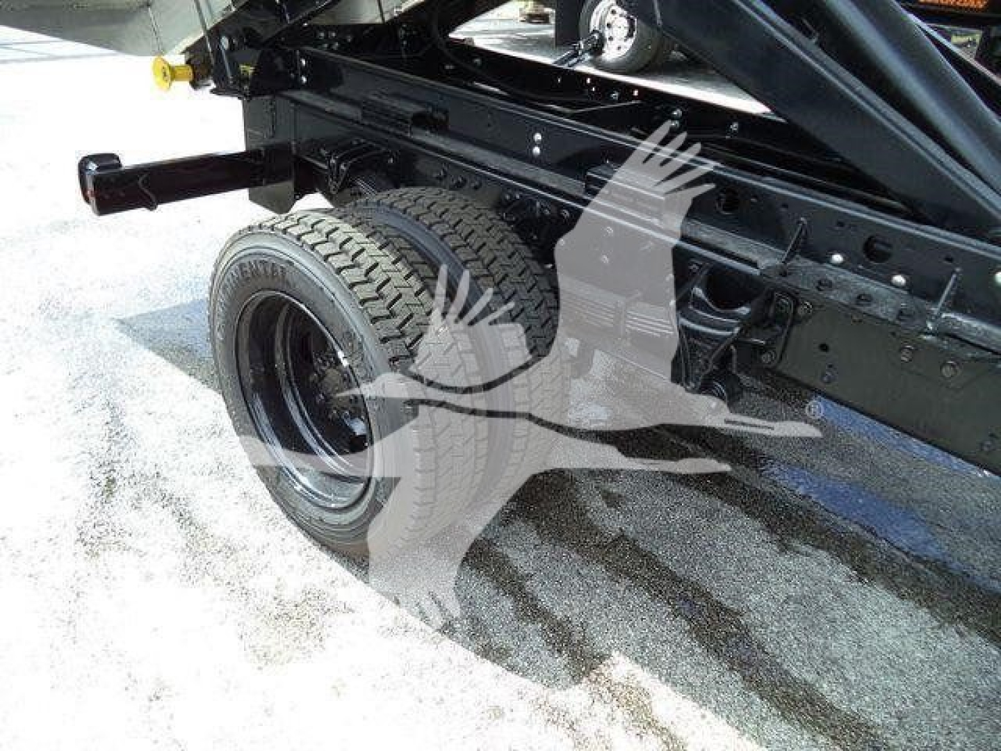 Truck chassis and rear wheel of a 2023 Chevrolet Silverado 6500Hd showing dual rear tires and chassis frame.