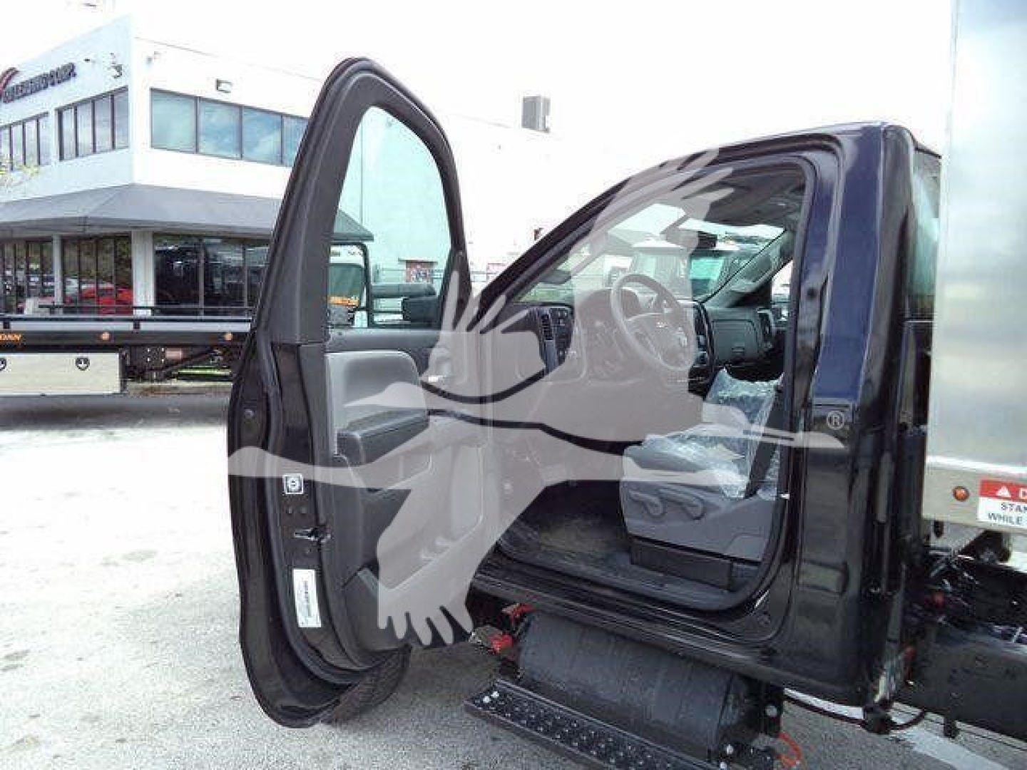 Chevrolet Silverado 6500HD truck with driver door open showing interior cab and steps.