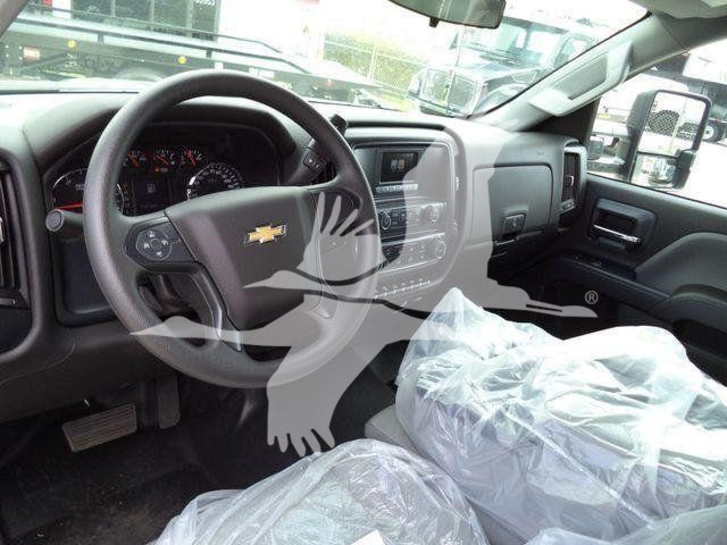 Chevrolet Silverado 6500Hd interior showing steering wheel with chevrolet emblem and dashboard.