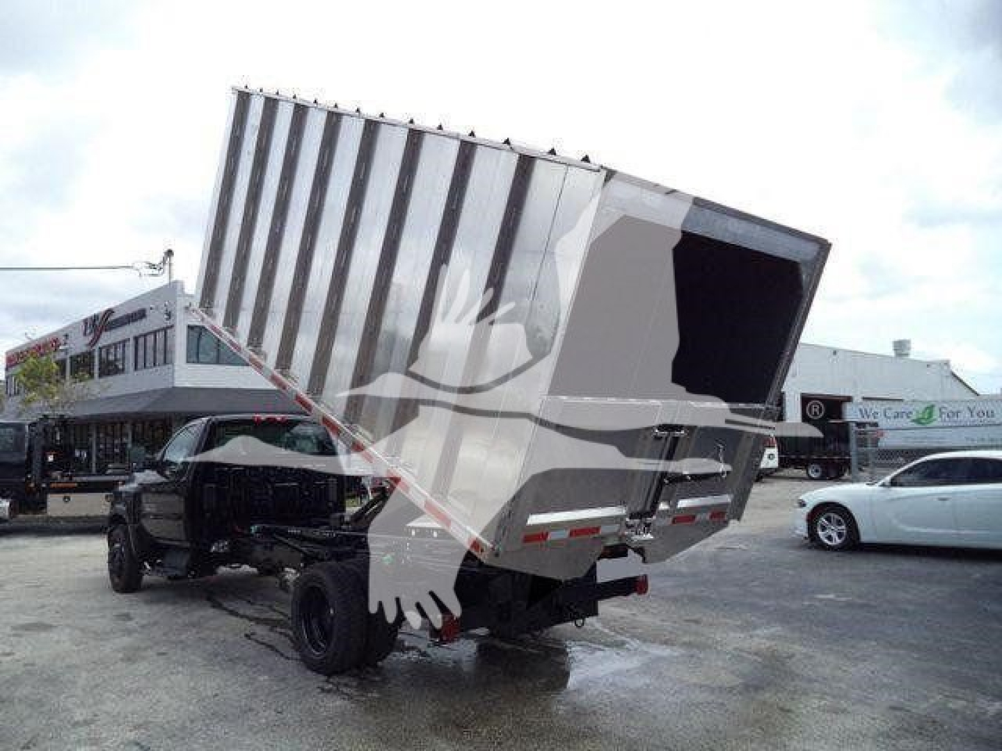 Dump truck chassis and tipping bed in raised position showing cargo area and rear wheels.