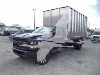 Chevrolet Silverado 6500HD truck with a large dump trailer in a parking lot, front-left view, stock number T05573FM visible.