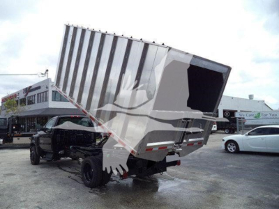 Dump truck chassis and tipping bed in raised position showing cargo area and rear wheels.