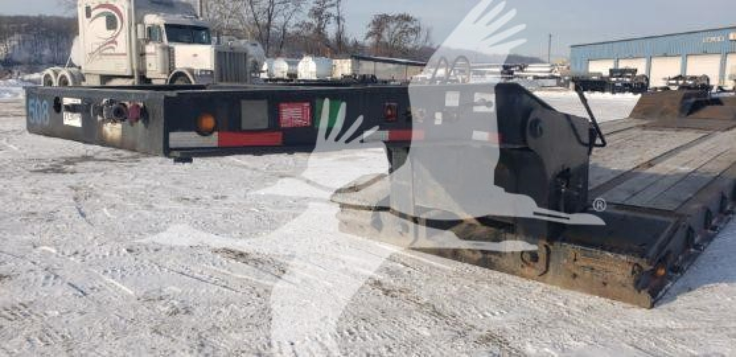 Lowboy trailer showing Load King beavertail in-service with reflective rear lights and license plate area.
