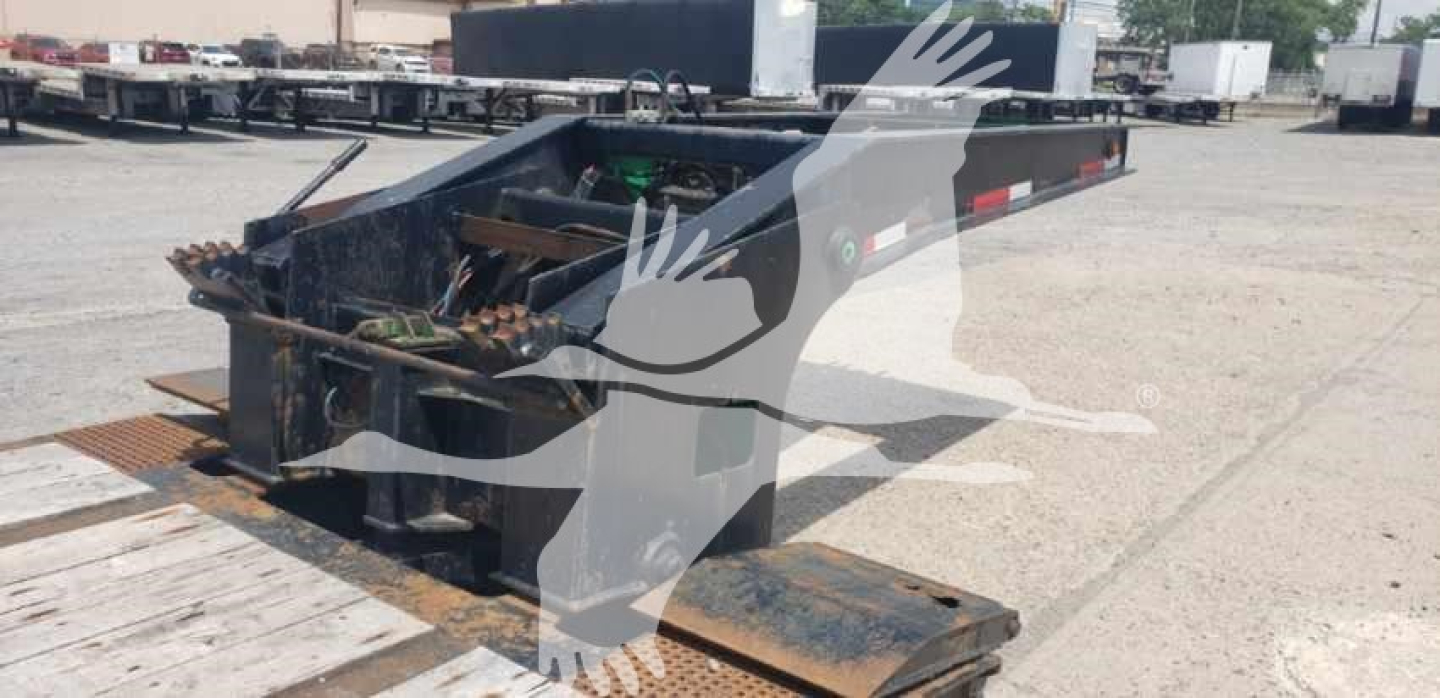 Lowboy trailer deck with beavertail section and serviceable rear storage, Load King platform chassis showing steel frame and hitch area, used condition.