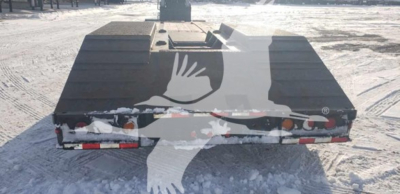 Load King beavertail lowboy trailer rear view showing taillights and snow on ground.