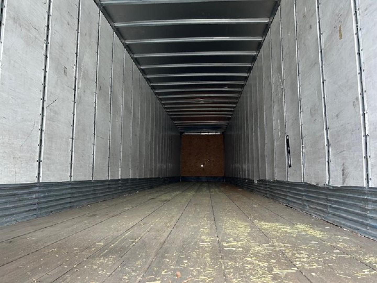 Trailer interior showing empty cargo area with metal walls and ceiling, wooden floor at front, 2014 Stoughton Air Ride Dry Van.
