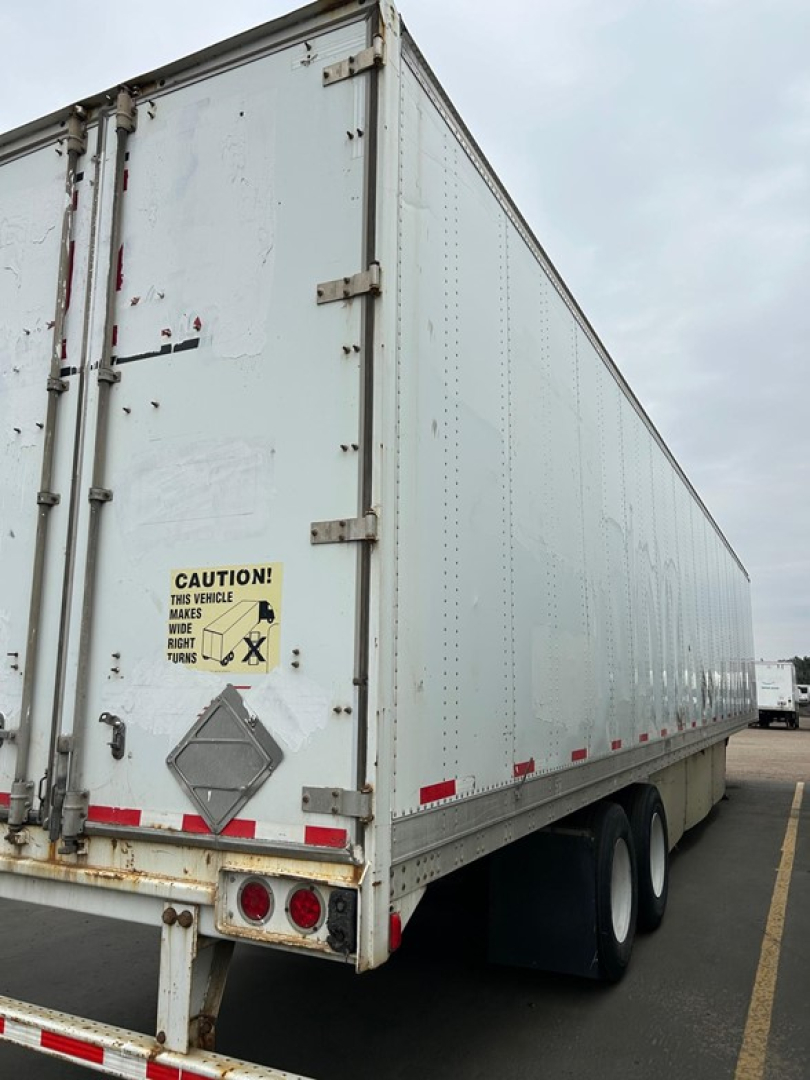 Trailer rear and side of a white Stoughton air ride dry van, with rear doors closed and hazard placard visible.