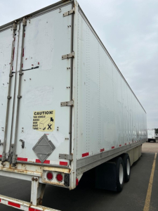 Stoughton air ride dry van trailer showing rear doors, warning sticker, and dual rear tires.