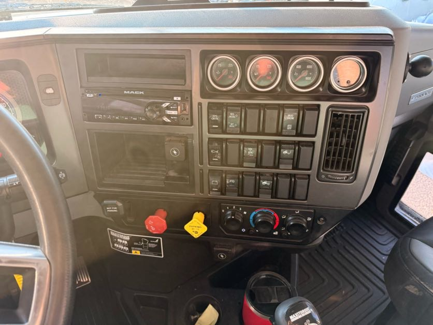 Mack Pinnacle truck dash showing gauges and control panel with switches and knobs.