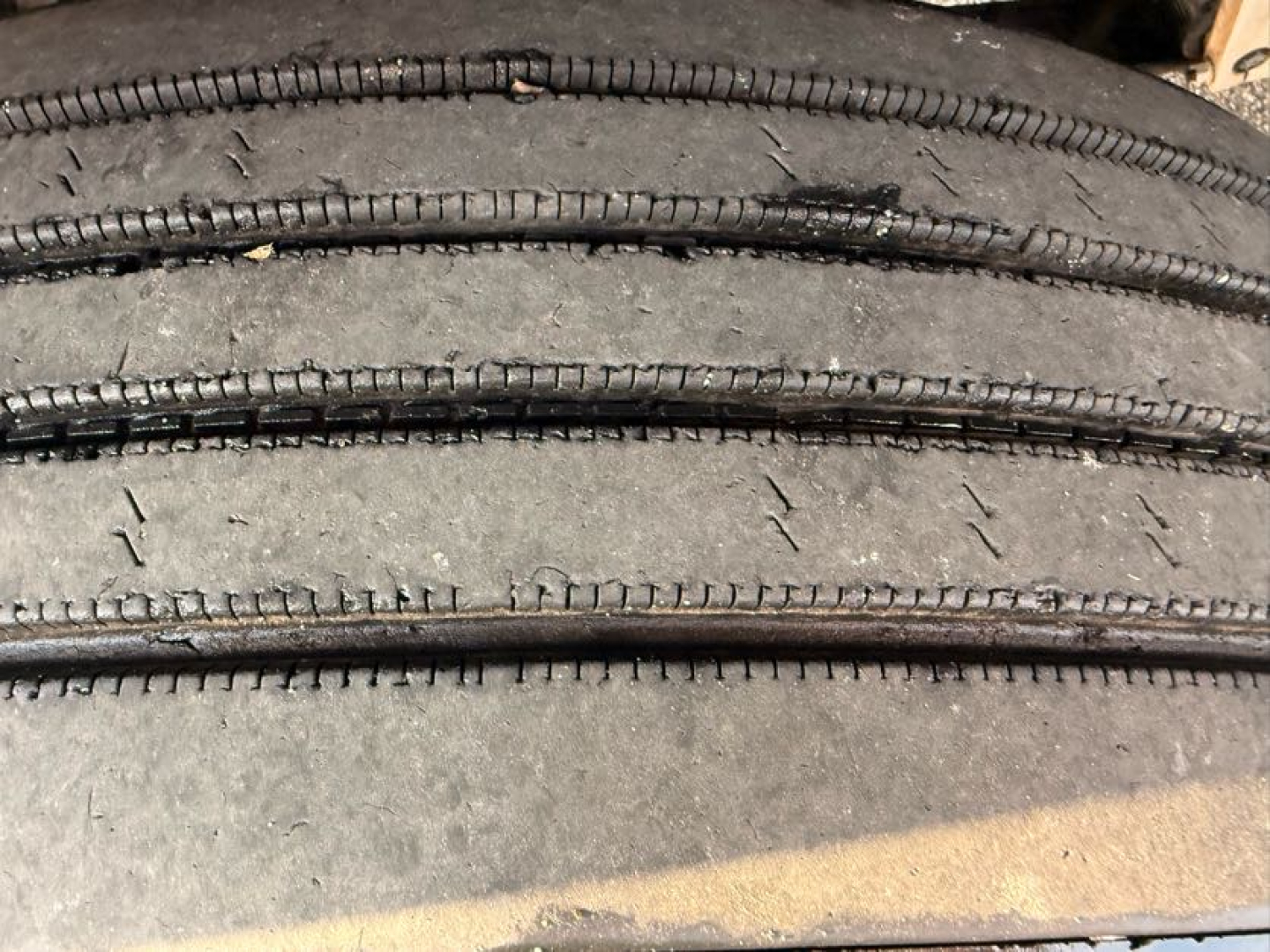 Tires stacked in a close-up view showing tread and sidewall texture on a truck wheel area.