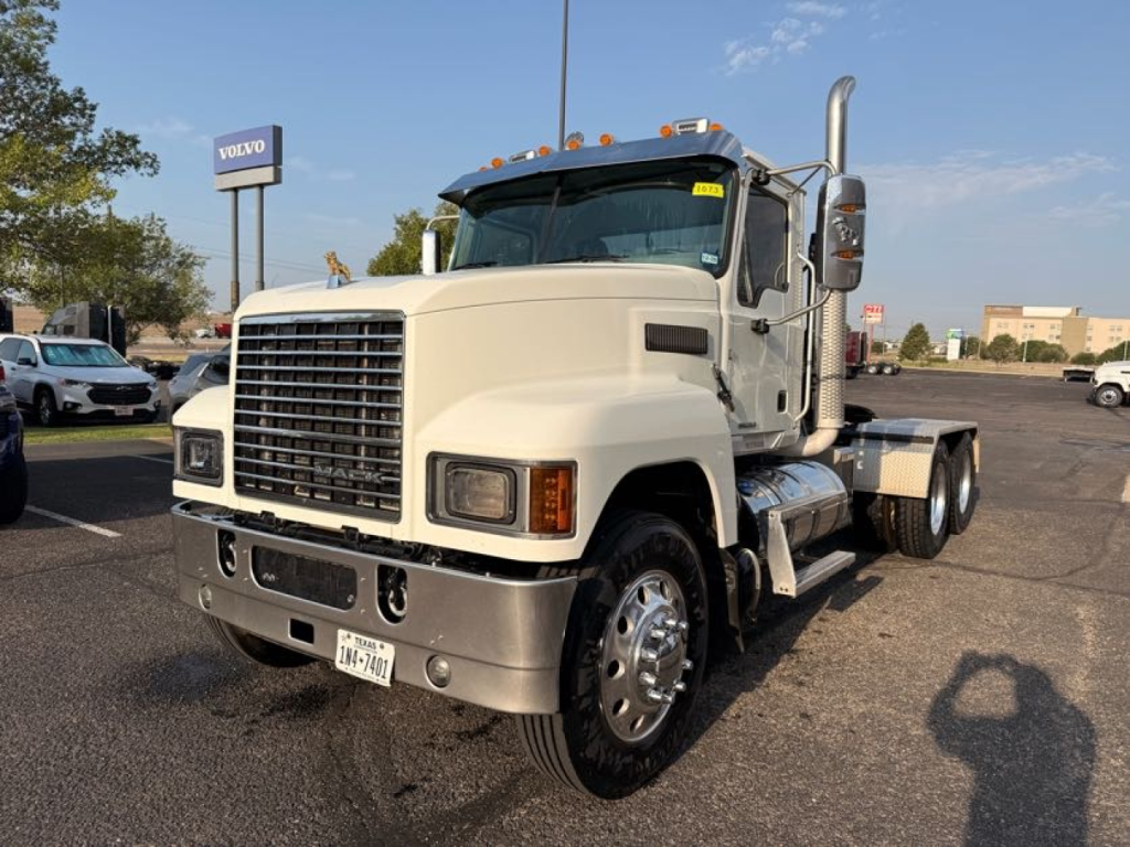 White 2020 Mack Pinnacle conventional daycab truck in a dealership lot, front view with large grille, chrome bumper, dual rear axles, and exhaust stack.