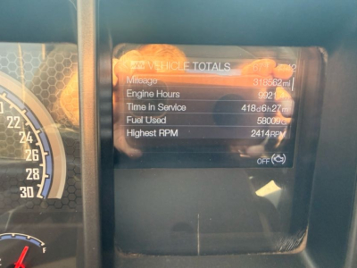 Dashboard display panel showing vehicle totals with mileage, engine hours, time in service, fuel used, and highest RPM on Mack Pinnacle truck.