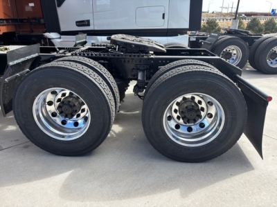 Dual rear axle of a new Mack PR64T76H truck showing dual-tire configuration and chrome wheels; visible frame and wheel hubs.