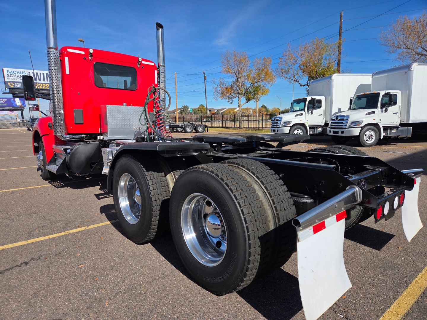 Kenworth T880 conventional daycab chassis showing dual rear axles and rear mud flaps.