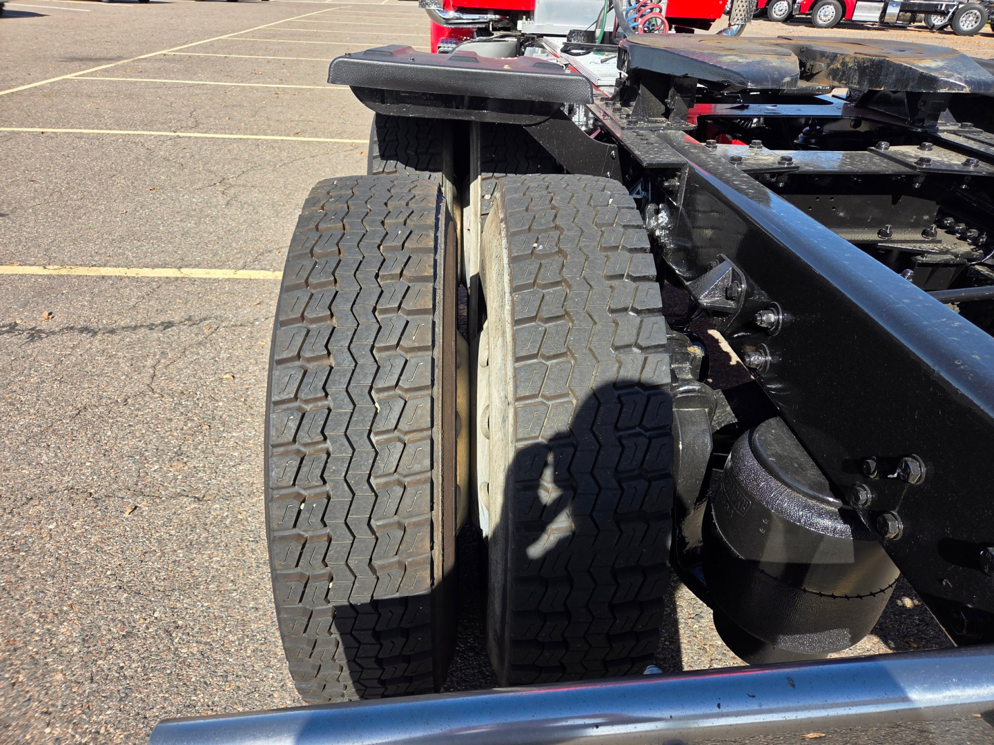 Dual rear tires of a 2020 Kenworth T880 tractor chassis with wheel hub and suspension components visible.