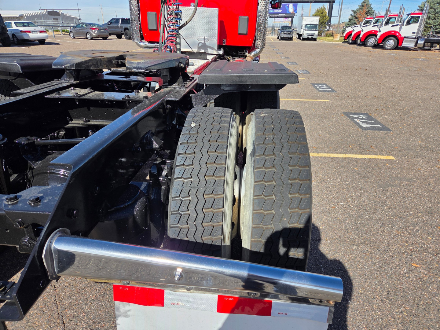 Kenworth T880 chassis showing dual rear wheels and frame components in a truck yard.