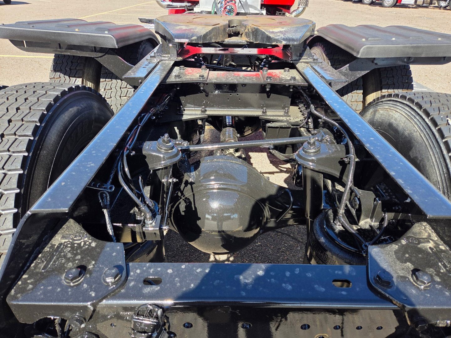 Kenworth T880 chassis rear view showing drivetrain differential axle, suspension links, and frame rails.