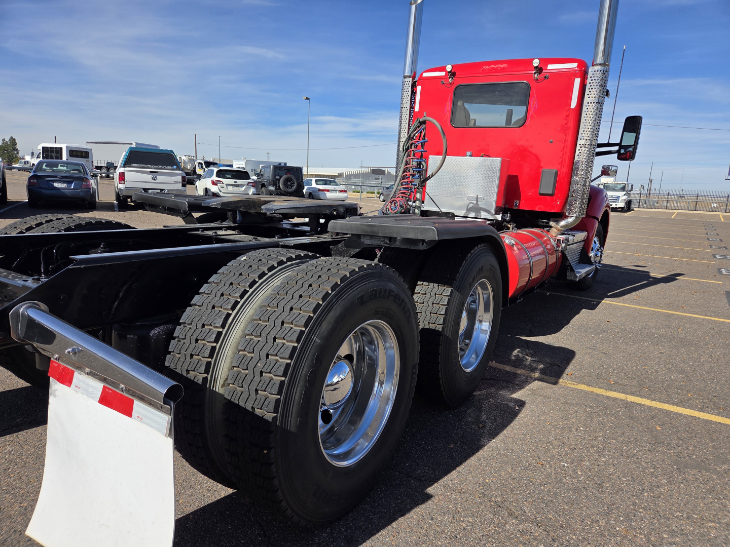 Kenworth T880 truck chassis and red sleeper cab from rear/right view showing dual rear axles and fifth wheel area.