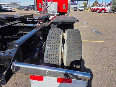 Kenworth T880 chassis showing dual rear wheels and frame components in a truck yard.