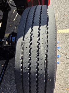 Kenworth T880 wheel/tire close-up in-service showing tread detail and dual rear axles.