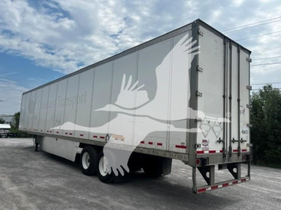 Trailer side showing Wagon Transport logo with white bird graphic; rear doors; aluminum trailer with wheels and landing gear visible.