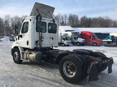 Freightliner Cascadia 113 truck chassis side rear view showing engine compartment and dual rear wheels.