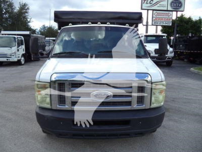 Front view of a white 2011 Ford E-450 dump truck with black front bumper and grille, large windshield, and dump bed in background.