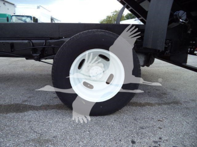 Ford E450 truck wheel and undercarriage showing white steel wheel and black frame.