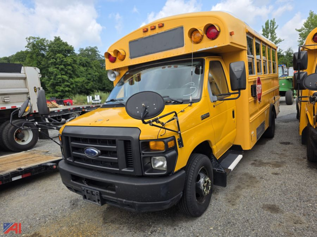 Ford E-Series school bus with yellow body and black front grille, side mirrors, and stop arm visible