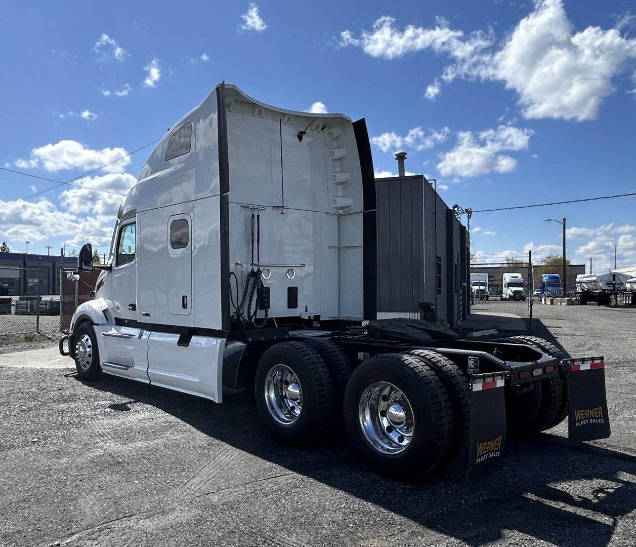 Peterbilt 579 conventional sleeper tractor rear three-quarter view showing dual rear axles and chrome wheels.