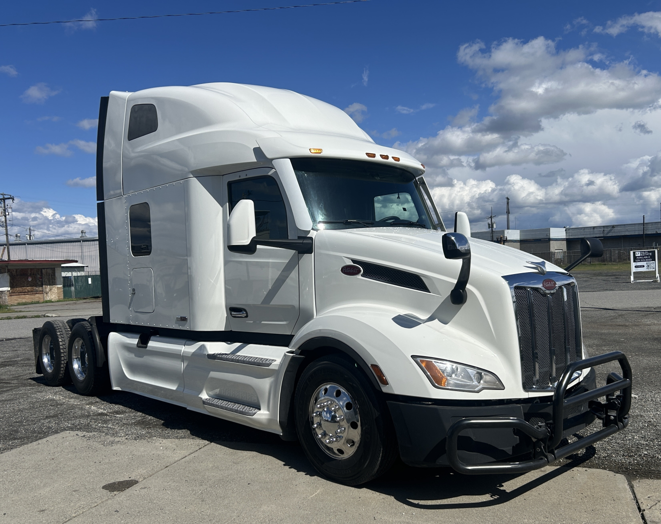 Peterbilt 579 semi-truck in white, side view, with sleeper cab and chrome wheels. No visible text on doors; cab features include aerodynamic mirrors and grille.