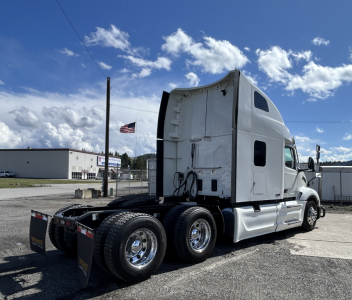 Peterbilt 579 semi truck in-value used condition shown from side/rear, sleeper cab, 6-wheel rear with chrome rims and dual rear axles; no visible text readable
