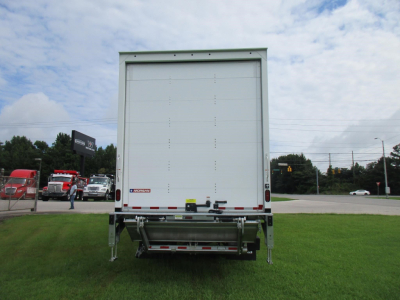 Rear view of a Freightliner M2 106 box truck trailer showing closed cargo doors and rear bumper with reflectors.