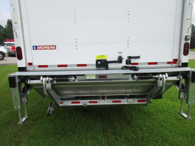 Rear view of a 2027 Freightliner M2 106 box truck showing Morgan hydraulic lift and rear bumper hardware with yellow warning sticker.