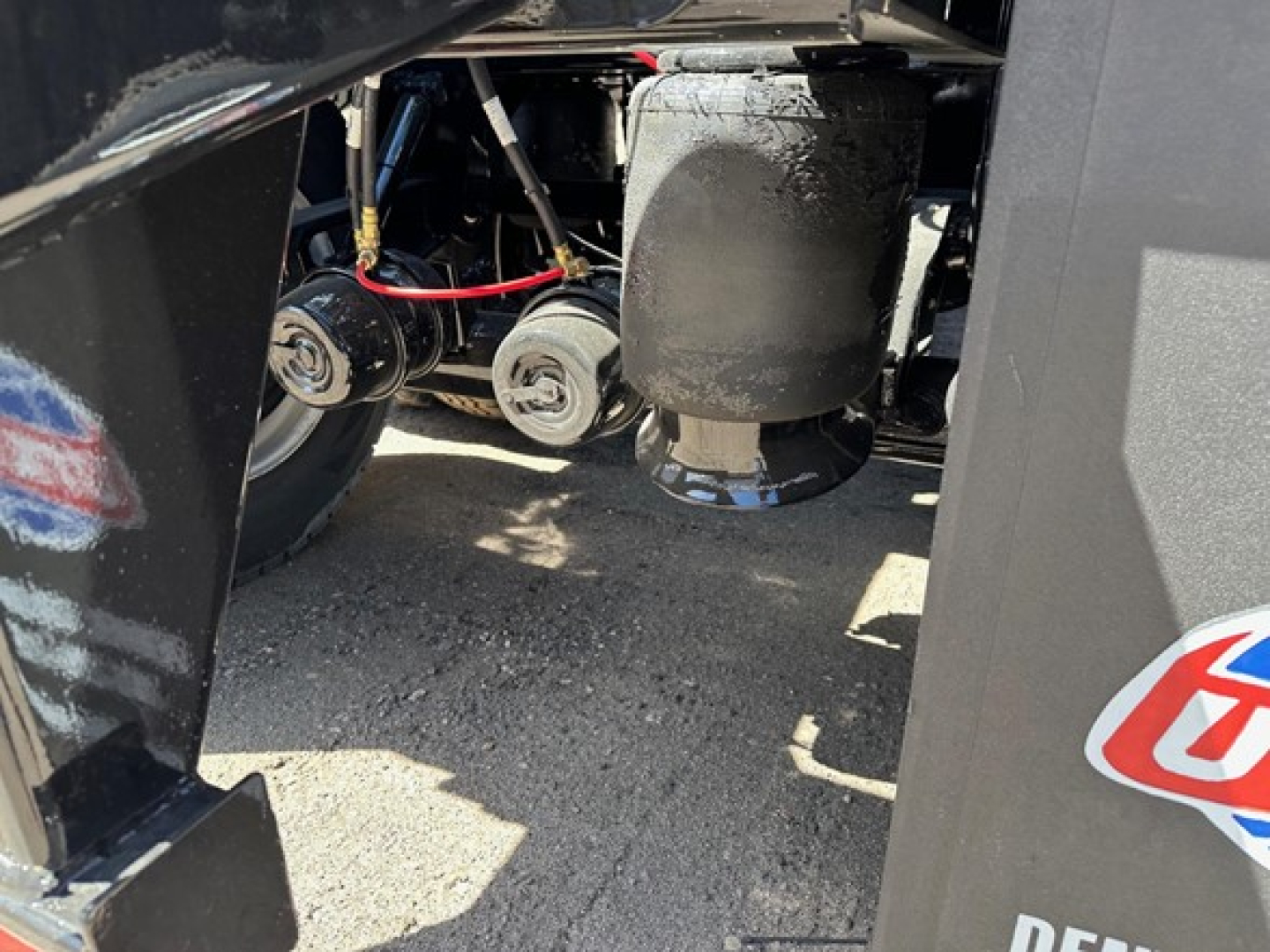 Jet Air Ride Side Dump trailer engine bay area showing hydraulic lines and mechanical components with a black cylindrical object and wiring near underside.