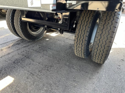 Dual rear axles of a new Jet Air Ride Side Dump trailer showing heavy-duty suspension and tires, undercarriage components visible.