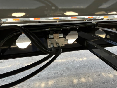 Trailer undercarriage showing hydraulic lines and mounting bracket for Jet Air Ride side dump trailer.