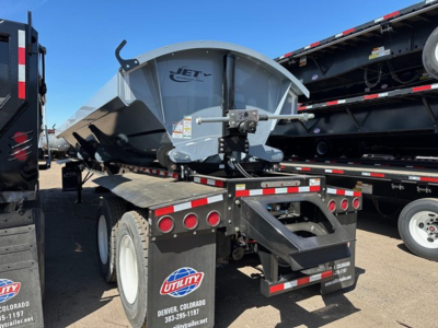 Jet side dump trailer on a flatbed showing rear framing, tires, and Jet logo on the dump body.