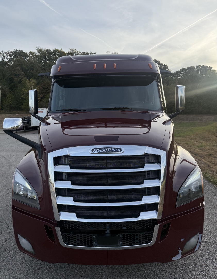 Freightliner Cascadia126 truck front view showing chrome grille and maroon body with side mirrors.