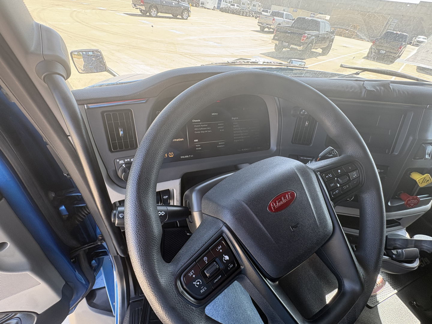 Peterbilt 579 cab interior with steering wheel and dashboard visible; shows steering controls and instrument cluster in view.
