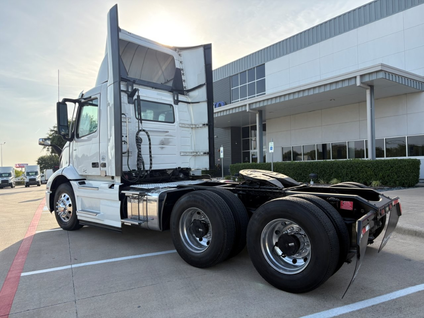Volvo VNR64T300 daycab tractor showing side and rear view with dual rear axles and exhaust stacks visible.