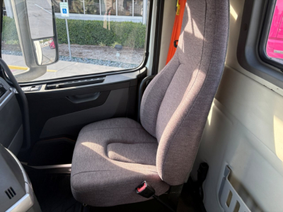 Volvo VNR64T300 cab interior with fabric seat and steering wheel visible.