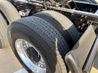 Rear dual tires on a Volvo VNR64T300 truck chassis showing dual rear wheels and chrome rim, part of the drive axle and frame.