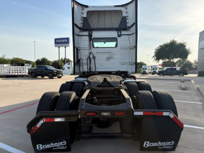 Truck chassis rear view showing fifth wheel, dual rear axles, and mud flaps with Bruckner's branding. Cab is white with exposed frame and rear window.