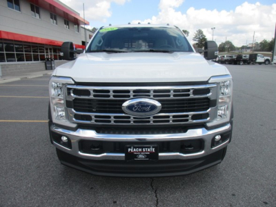 Front view of a white 2026 Ford F-450 flatbed truck showing chrome grille, Ford emblem, and bumper with Peach State license plate frame.