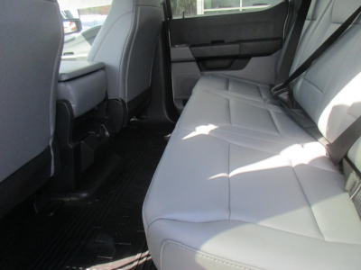 Ford F-450 interior rear seating view with light gray/white upholstery in a flatbed truck cabin.