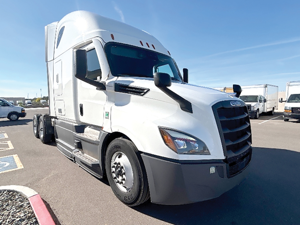 Truck front-left view of a white 2023 Freightliner Cascadia126 conventional sleeper tractor. Visible text includes Freightliner badge on grille, side mirrors, fuel tanks, and cabin door.