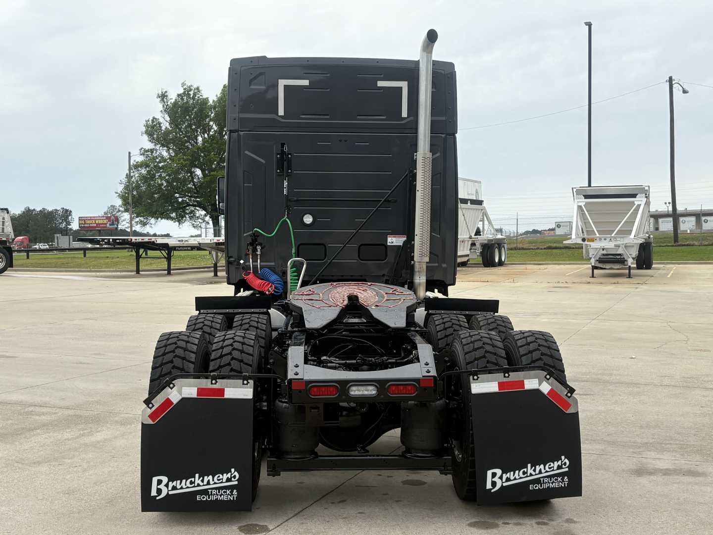 Rear view of a 2027 Mack AN64T64 truck tractor showing dual rear axles, mud flaps with Bruckner's Equipment logo, and license-area details.